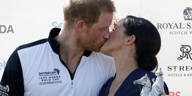 Meghan, Duchess of Sussex and Britain's Prince Harry kiss during the presentation ceremony for the Sentebale ISPS Handa Polo Cup at the Royal County of Berkshire Polo Club in Windsor, England, Thursday, July 26, 2018.(AP Photo/Matt Dunham)