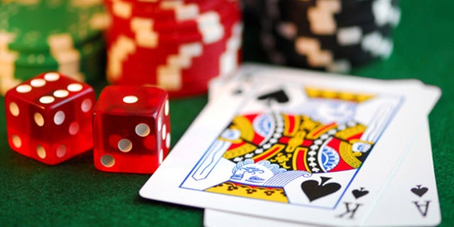 Stacks of gambling chips, playing cards and dice on green background