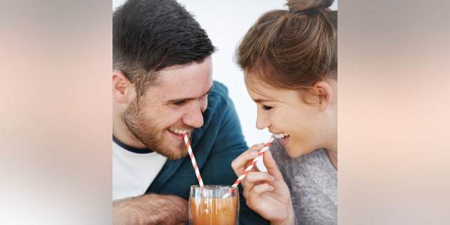 Shot of an attractive young couple sharing a milkshake together