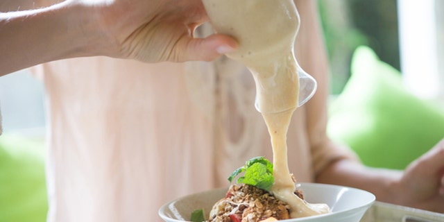 Woman pouring cream sauce