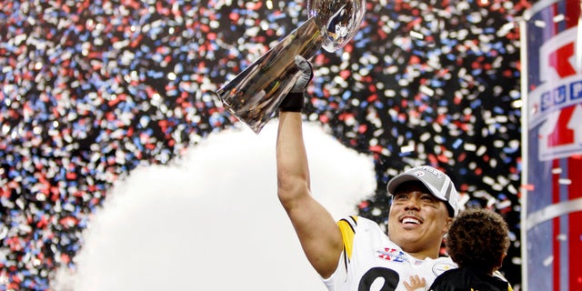 Pittsburgh Steelers wide receiver Hines Ward holds his son as he waves the Vince Lombardi Trophy after the Steelers beat the Seattle Seahawks 21-10 in the NFL's Super Bowl XL in Detroit, Michigan February 5, 2006.