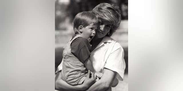 Young Prince Harry, 3, yawns as his mother Princess Diana holds him during a morning picture session at Marivent Palace.