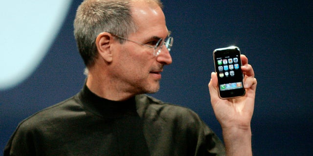 Steve Jobs, then CEO of Apple, holds an iPhone in San Francisco, California, on January 9, 2007.