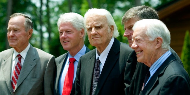 Former U.S. Presidents George H.W. Bush, Bill Clinton and Jimmy Carter pose with Billy Graham and his son, Franklin Graham.