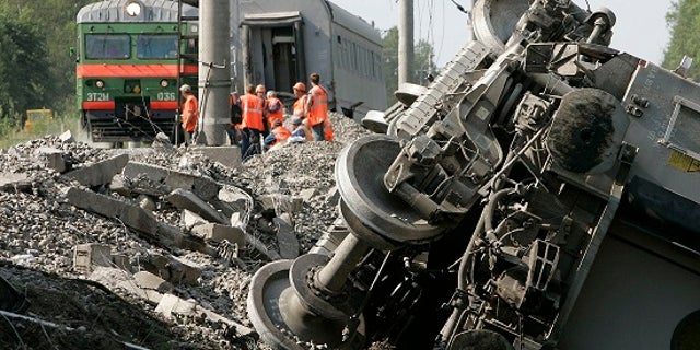 Rescuers work at the site of a train that derailed northwest of Moscow after a bomb exploded.