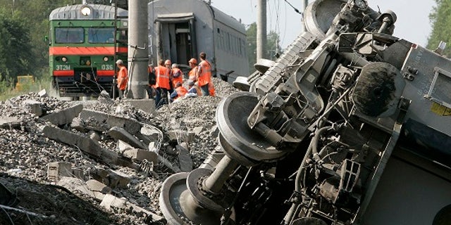 Rescuers work at the site of a train that derailed northwest of Moscow after a bomb exploded.