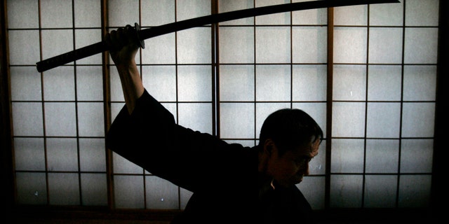 Japanese man holds a samurai sword. (Reuters)