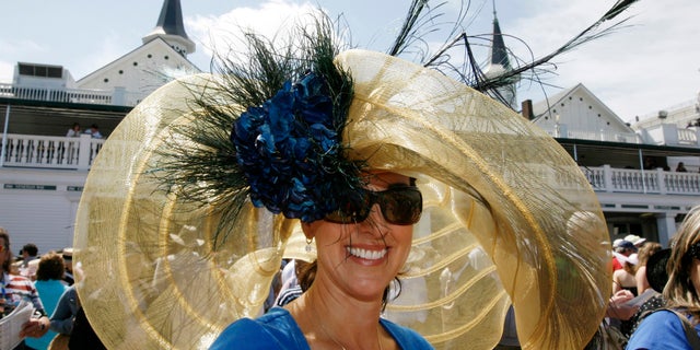 Race fan Julie Casteel displays her hat before the 134th running of the Kentucky Derby horse race.