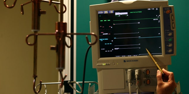File photo: A nurse points to an Electrocardiograph (EKG) machine with a copper pen next to a copper IV drip stand at the Copper Hospital in Calama city, north of Santiago March 31, 2011. (REUTERS/Ivan Alvarado)