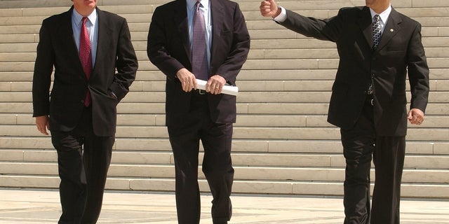 Sen. John McCain, along with Rep. Marty Meehan, D-Mass.; and Sen. Russ Feingold, D-Wis.; walk across the Supreme Court Plaza after attorneys made oral arguments during a special session of the Supreme Court on the constitutionality of the McCain-Feingold campaign finance reform law.