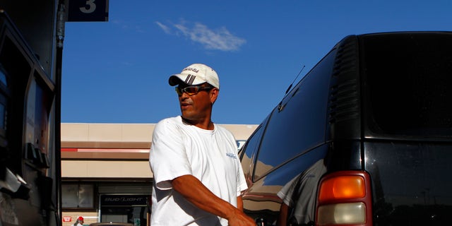 FILE --  August 2011: A motorist pumps fuel into his vehicle at JJ's Express Gas Plus station in Phoenix gas station in Phoenix, Arizona.