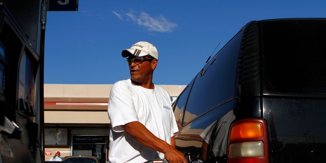 FILE -- August 2011: A motorist pumps fuel into his vehicle at JJ's Express Gas Plus station in Phoenix gas station in Phoenix, Arizona.