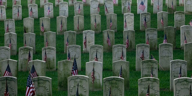 U.S. flags are placed on gravestones of military veterans at the Cyprus Hills National Cemetery in New York May 27, 2012. REUTERS/Allison Joyce (UNITED STATES - Tags: MILITARY SOCIETY CONFLICT) - RTR32Q65