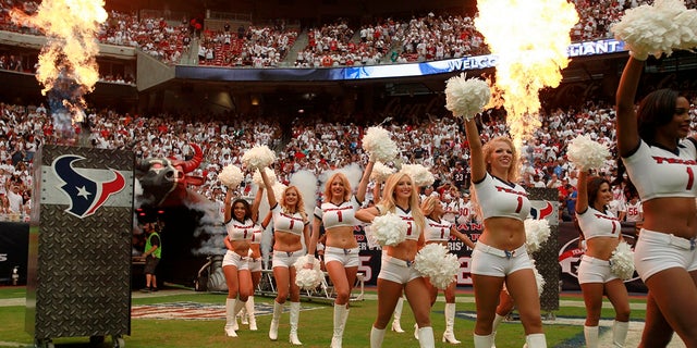 The Houston Texans cheerleaders enter the field surrounded by smoke and flame during the opening ceremonies of the season opening NFL football game against the Miami Dolphins in Houston, Sept. 9, 2012.