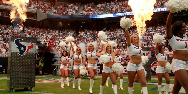 The Houston Texans cheerleaders enter the field surrounded by smoke and flame during the opening ceremonies of the season opening NFL football game against the Miami Dolphins in Houston, Sept. 9, 2012.