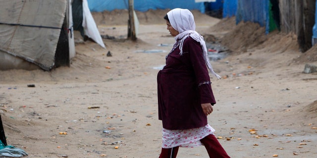 A pregnant Syrian woman walks at a refugee camp in the city of Tyre, in southern Lebanon January 31, 2013. REUTERS/Ali Hashisho