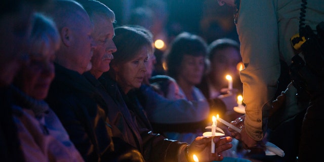 Carl and Marsha Mueller hold candles during a memorial honoring Kayla in February 2015. (REUTERS)