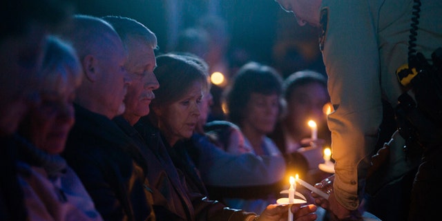 Carl and Marsha Mueller hold candles during a memorial honoring Kayla in February 2015. (REUTERS)