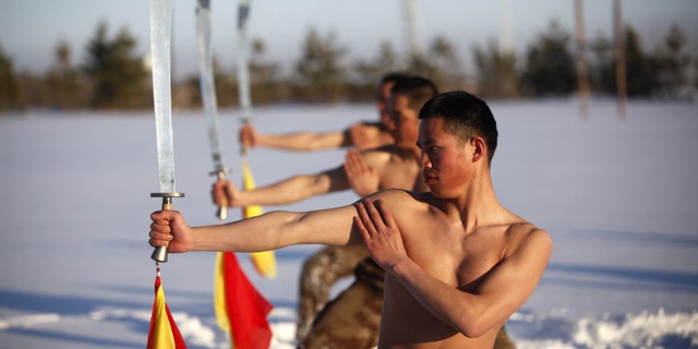 File photo: Soldiers of China's People's Liberation Army (PLA) practice with swords as they take part in a winter training at China's border with Russia in Heihe, Heilongjiang province, February 27, 2015.