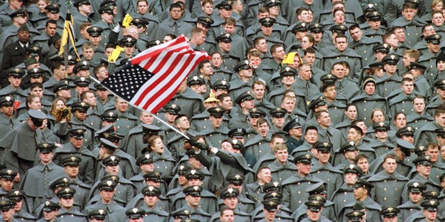 A lone West Point Cadet waves the American flag amid a sea of fellow Cadets as they watch Navy take a commanding lead in the first half of the Army-Navy game, December 6 1997 at Giants Stadium in East Rutherford.