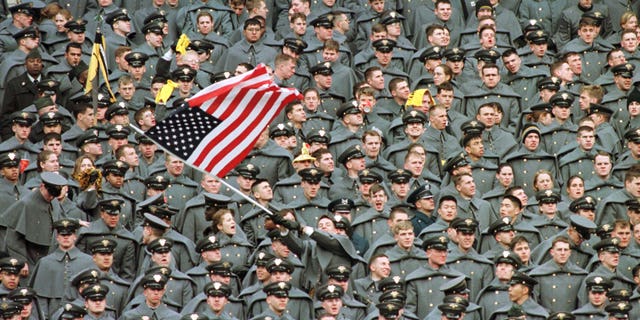 A lone West Point Cadet waves the American flag amid a sea of fellow Cadets as they watch Navy take a commanding lead in the first half of the Army-Navy game, December 6 1997 at Giants Stadium in East Rutherford.