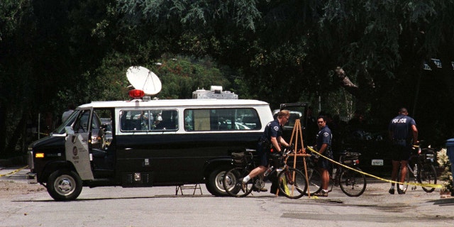 A Los Angeles Police Department van sits in the street near the driveway to the home of actor Phil Hartman May 28, 1998 in Encino, California.
