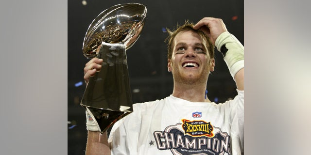 New England Patriots quarterback Tom Brady holds the Vince Lombardi Trophy after winning Super Bowl XXXVIII in Houston, February 1, 2004.
