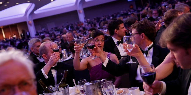 Attendees at the White House Correspondents' Association dinner in Washington raising their glasses.
