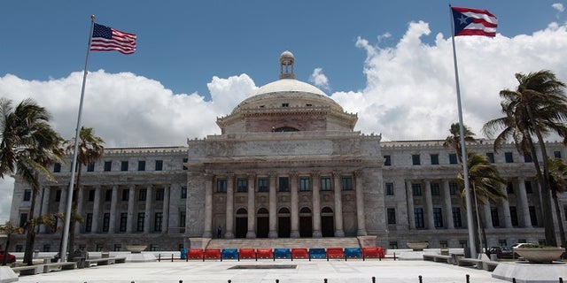 FILE -- The flags of the U.S. and Puerto Rico fly outside the Capitol building in San Juan, Puerto Rico May 4, 2017.