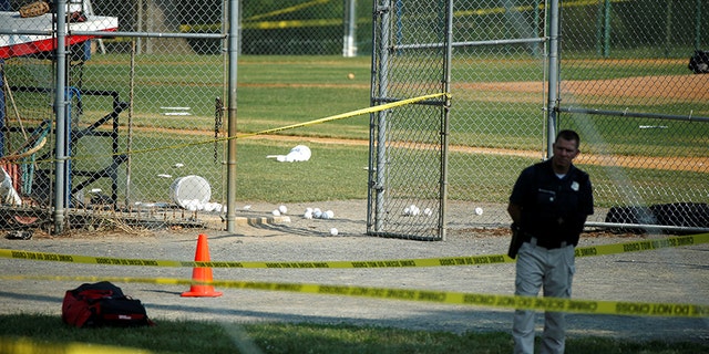 A police officer stands by the Alexandria shooting scene.