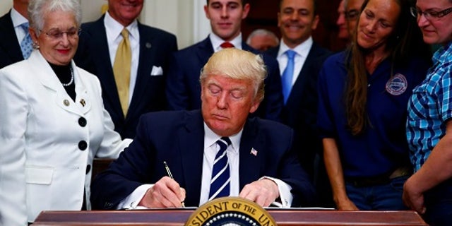 U.S. President Donald Trump signs an executive order at the White House in Washington, U.S. June 15, 2017. REUTERS/Eric Thayer - RTS178B1
