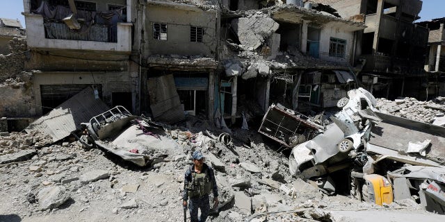 A member of the Iraqi federal police patrols in the destroyed Old City of Mosul, Iraq in August.