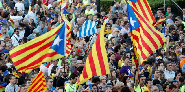 People hold Esteladas (Catalan separatist flags) as they wait for a closing rally in favour of the banned October 1 independence referendum in Barcelona, Spain September 29, 2017.