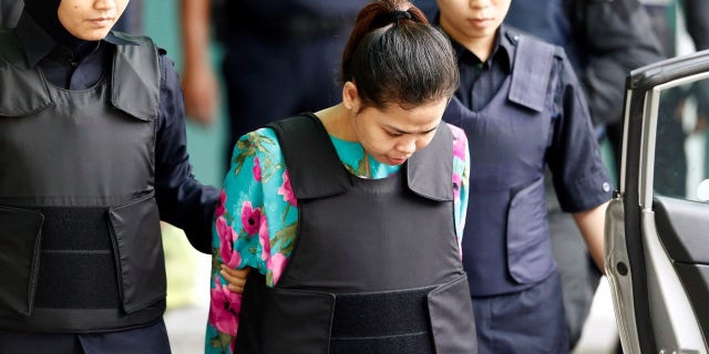 Indonesian Siti Aisyah, who is on trial for the killing of Kim Jong Nam, is escorted into Kuala Lumpar airport.
