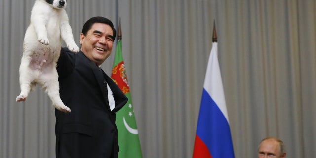 Turkmenistan's President Gurbanguly Berdimuhamedov holds up a Turkmen shepherd dog.