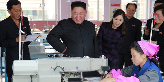 Kim Jong-Un and his rarely-photographed wife, Ri Sol Ju, right of Kim, visit Ryuwon Footwear Factory.