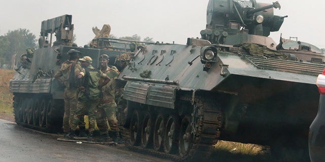 Soldiers stand beside a military vehicle outside Harare, Zimbabwe.