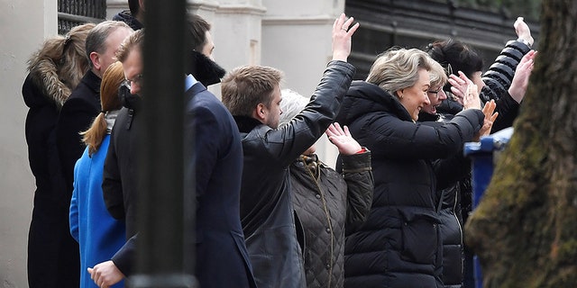 Embassy staff wave as colleagues and children board buses outside Russia's Embassy in London.