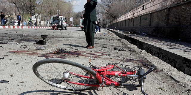 An Afghan man inspects the site of a suicide attack in Kabul.