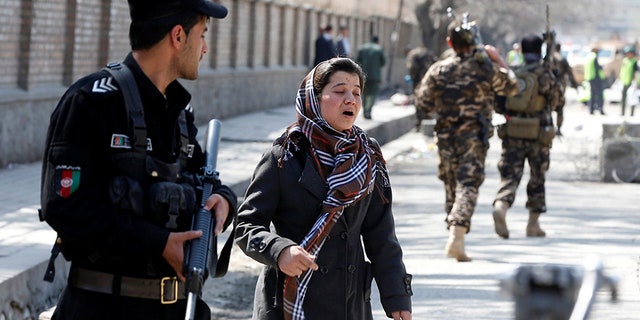 An Afghan woman seeks for her relative at the site of a suicide in Kabul.