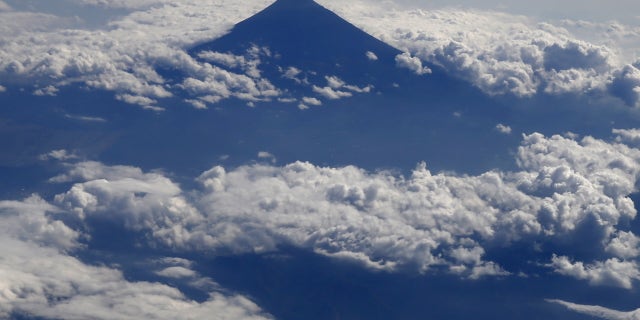 Japan's Mount Fuji, surrounded by cloud, is seen from an airplane October 6, 2015. Mount Fuji, at 3,776 metres (12,388 ft) is Japan's highest mountain. REUTERS/Toru Hanai - RTS3757