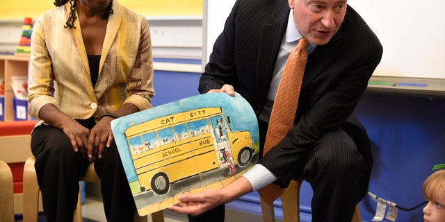 New York City Mayor Bill de Blasio (R) reads a book to pre-K students on their first day of school at Public School 59 in Staten Island, New York, September 9, 2015.  At left is First Lady Chirlane McCray.  REUTERS/Barry Williams/Pool
