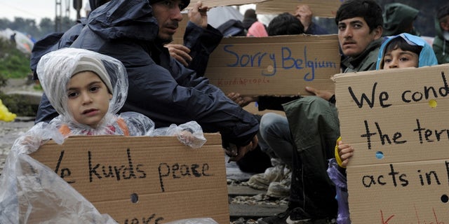 March 23, 2016: Refugees and migrants hold placards during a protest demanding the opening of the Greek-Macedonian border. (Reuters)