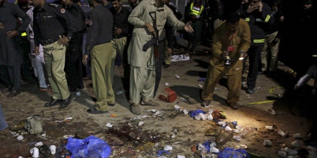 Security officials gather at the site of a blast in Lahore, Pakistan.