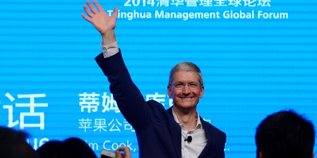 Apple CEO Tim Cook waves as he attends a talk in Beijing October 23, 2014.