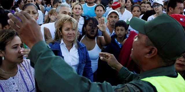 Venezuelan citizens listen to a national guardsman as they try to cross over the Simon Bolivar international bridge to Colombia to take advantage of the temporary border opening in San Antonio del Tachira. (REUTERS)