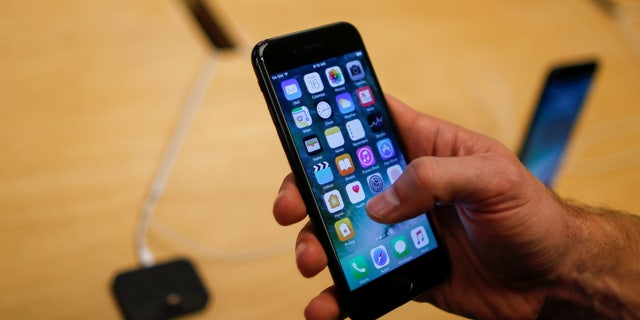 A customer takes a look at the new iPhone 7 smartphone inside of an Apple Inc. store in New York, U.S., September 16, 2016. (REUTERS/Eduardo Munoz)
