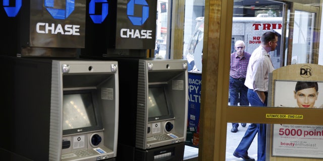 JPMorgan Chase ATMs stand near a door as customers walk past a Duane Reade store in New York, U.S., October 3, 2016. (REUTERS/Lucas Jackson)