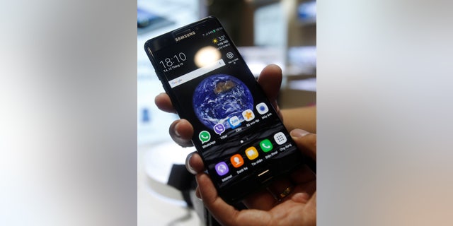 A man holds his mobile phone Samsung Galaxy Note 7 at a mobile phone shop in Hanoi, Vietnam October 12, 2016.