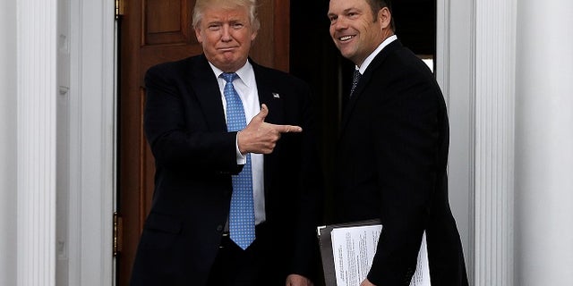 U.S. President-elect Donald Trump stands with Kansas Secretary of State Kris Kobach before their meeting at Trump National Golf Club in Bedminster, New Jersey, U.S., November 20, 2016. REUTERS/Mike Segar - RTSSISM